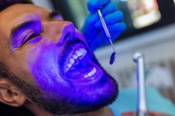 Female Dentist Using Curing Light During Dental Treatment
