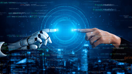 A dramatic visual representation of a human hand reaching out to a robotic hand, symbolizing the...