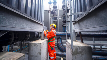 Engineer performs maintenance on industrial machinery in a power plant setting