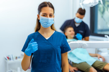 Female Dentist in Blue Coat Showing Thumbs Up