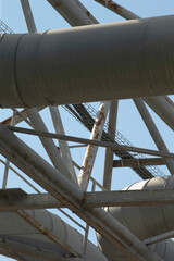 A collection of various pipes are suspended from a sturdy metal framework, creating a complex and...