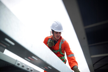 Construction worker inspecting metal beams at a building site during cloudy weather