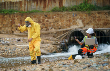 Environmental monitoring team investigates water quality near a drainage site during daylight hours