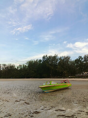 Fototapeta premium A fishing boat on the receding beach.
