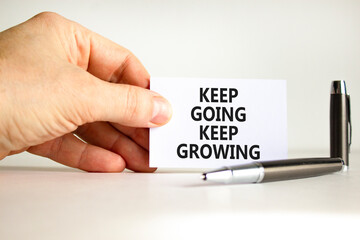 Keep going and growing symbol. Concept words phrase Keep going keep growing on beautiful card. Businessman's hand. Beautiful white paper background. Business Keep going and growing concept. Copy space