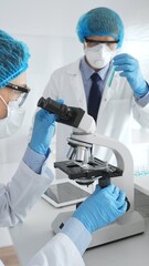 Two scientists in lab coats, face masks, and protective glasses conducting research with a...