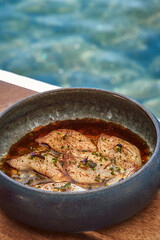 A Beautifully Plated Dish of Delicate Fish Garnished with Spices, Herbs, and Sauces Sitting Elegantly in a Bowl Against a Serene Aquatic Background