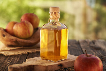 Apple cider vinegar in a glass bottle on a table outdoors