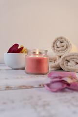 Spa table painted white with flower petals, towels, and candles
