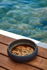 A beautifully presented dish of marinated fish fillets in a bowl, set against a stunning aquatic...