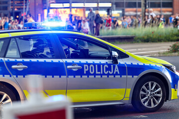 Żółto srebrny radiowóz służbowy policji w mieście