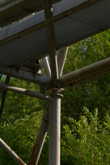 This image features a detailed closeup view of a sturdy metal structure, while trees can be seen...