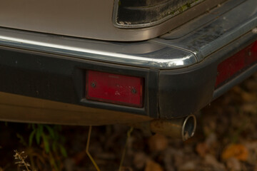 This image showcases a closeup view of a cars tail light as well as its exhaust pipe, highlighting...