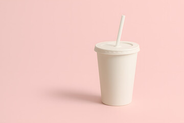 Stock photo of paper cup with straw on pink background for mockups