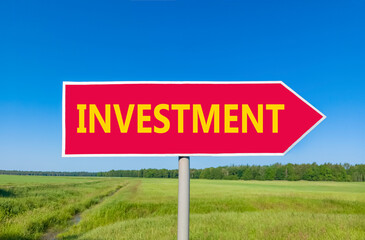 Investment symbol. Concept word Investment on beautiful red road sign. Beautiful blue sky green grass and forest peaceful nature background. Business investment concept. Copy space.