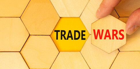 Trade wars symbol. Concept word Trade wars on beautiful wooden puzzles. Businessman's hand....