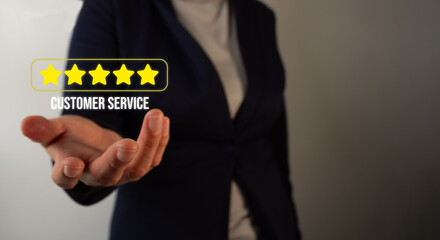 Businesswoman holding a five-star customer service rating in her hand