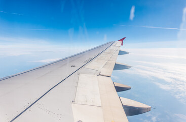 View from the airplane window at a beautiful cloudy sky and the airplane wing