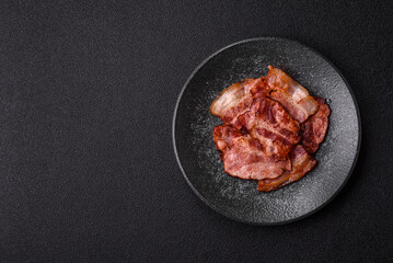 Cooked fried crispy bacon as an ingredient of a delicious English breakfast. Pieces of fried bacon