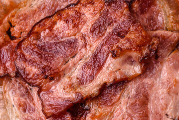 Cooked fried crispy bacon as an ingredient of a delicious English breakfast. Pieces of fried bacon