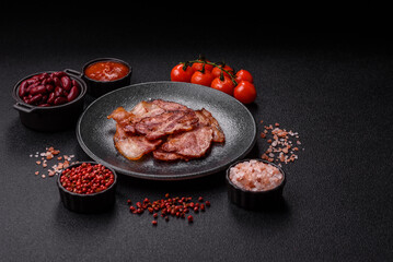 Cooked fried crispy bacon as an ingredient of a delicious English breakfast. Pieces of fried bacon