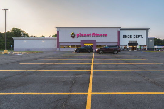 New Hartford, NY - Aug 2, 2025: Ultra-wide view of Crossroad Plaza parking lot in foreground, and Planet Fitness and Shoe Dept. in background