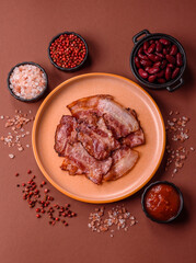 Cooked fried crispy bacon as an ingredient of a delicious English breakfast. Pieces of fried bacon