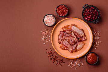Cooked fried crispy bacon as an ingredient of a delicious English breakfast. Pieces of fried bacon