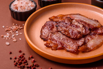 Cooked fried crispy bacon as an ingredient of a delicious English breakfast. Pieces of fried bacon
