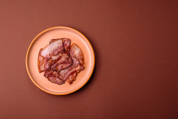 Cooked fried crispy bacon as an ingredient of a delicious English breakfast. Pieces of fried bacon