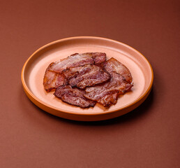 Cooked fried crispy bacon as an ingredient of a delicious English breakfast. Pieces of fried bacon