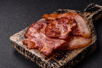 Cooked fried crispy bacon as an ingredient of a delicious English breakfast. Pieces of fried bacon
