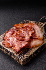 Cooked fried crispy bacon as an ingredient of a delicious English breakfast. Pieces of fried bacon