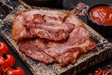 Cooked fried crispy bacon as an ingredient of a delicious English breakfast. Pieces of fried bacon