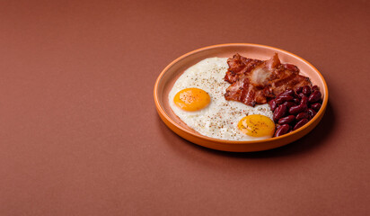 Fried egg, bacon and beans, a classic British breakfast with tomatoes. Egg, bacon and beans
