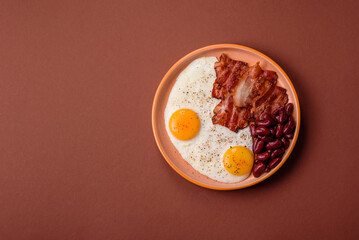Fried egg, bacon and beans, a classic British breakfast with tomatoes. Egg, bacon and beans