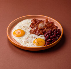 Fried egg, bacon and beans, a classic British breakfast with tomatoes. Egg, bacon and beans