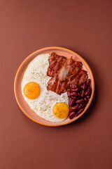 Fried egg, bacon and beans, a classic British breakfast with tomatoes. Egg, bacon and beans