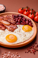 Fried egg, bacon and beans, a classic British breakfast with tomatoes. Egg, bacon and beans