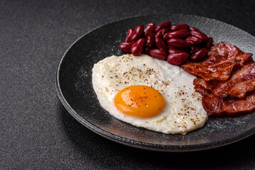 Fried egg, bacon and beans, a classic British breakfast with tomatoes. Egg, bacon and beans