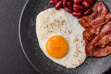 Fried egg, bacon and beans, a classic British breakfast with tomatoes. Egg, bacon and beans
