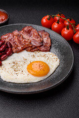 Fried egg, bacon and beans, a classic British breakfast with tomatoes. Egg, bacon and beans