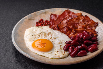 Fried egg, bacon and beans, a classic British breakfast with tomatoes. Egg, bacon and beans