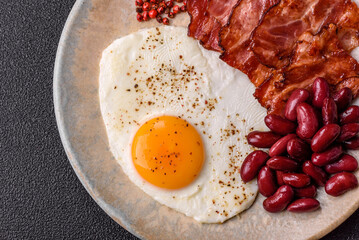 Fried egg, bacon and beans, a classic British breakfast with tomatoes. Egg, bacon and beans