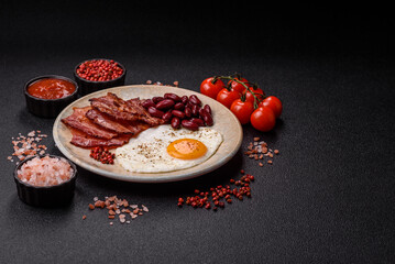 Fried egg, bacon and beans, a classic British breakfast with tomatoes. Egg, bacon and beans
