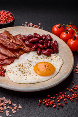 Fried egg, bacon and beans, a classic British breakfast with tomatoes. Egg, bacon and beans