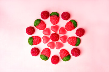 Circle of gummy candies forming a flower on pink background