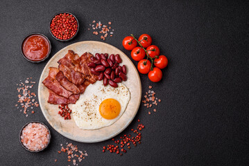 Fried egg, bacon and beans, a classic British breakfast with tomatoes. Egg, bacon and beans