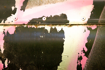 A detailed close up image showcasing a piece of metal that has paint peeling off its surface,...