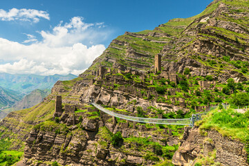 Modern mountain suspension bridge leading to the ruins of the village of Kakhib. North Caucasus